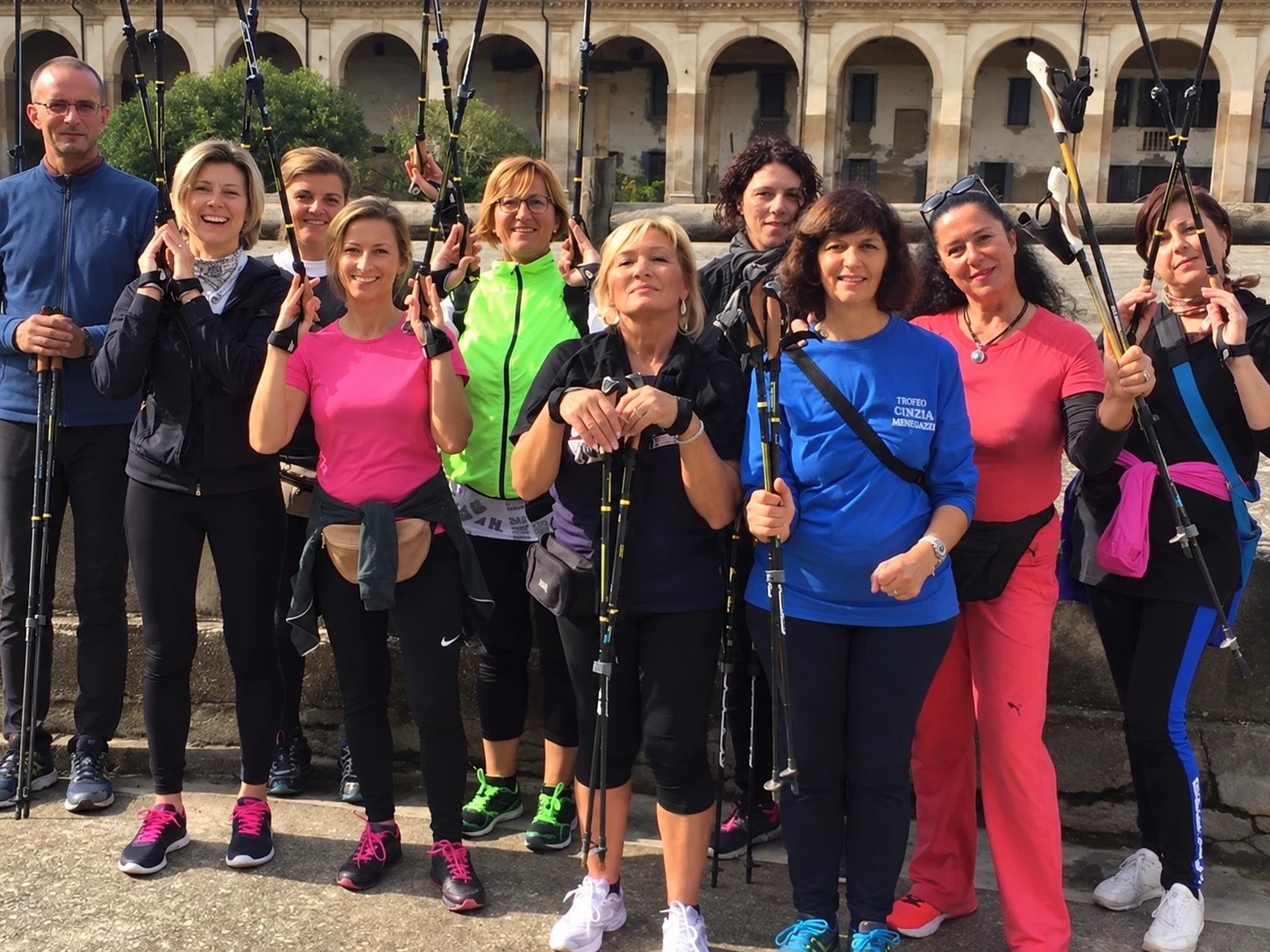 Il gruppo di camminatrici e camminatori sorride con i bastoncini in mano davanti a una villa veneta