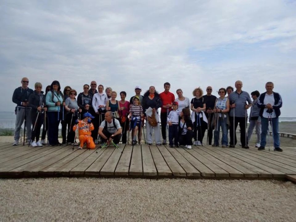Il gruppo in posa con i bastoncini su una pedana di legno vicino all’acqua